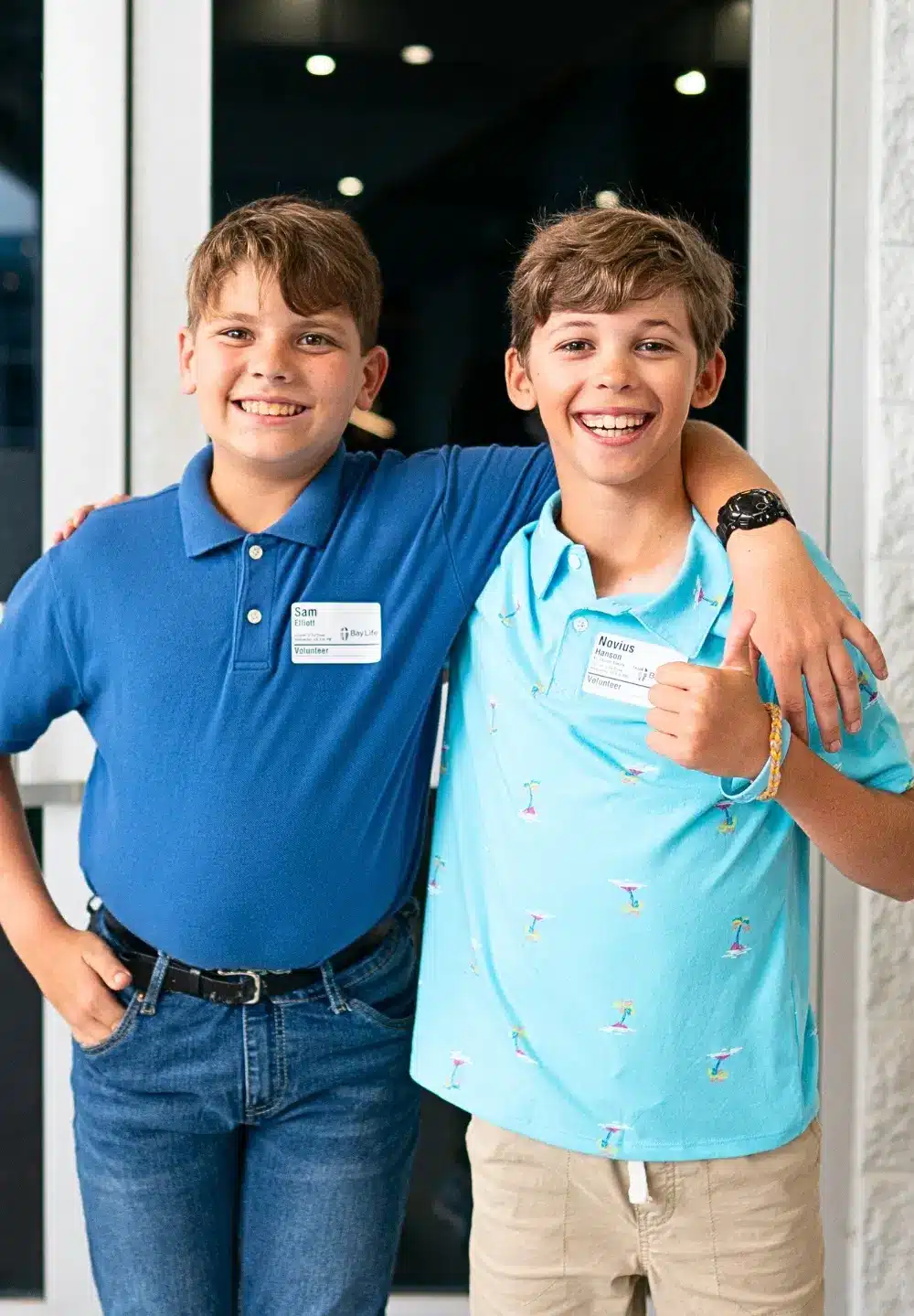 two boys take a picture in front of worship center